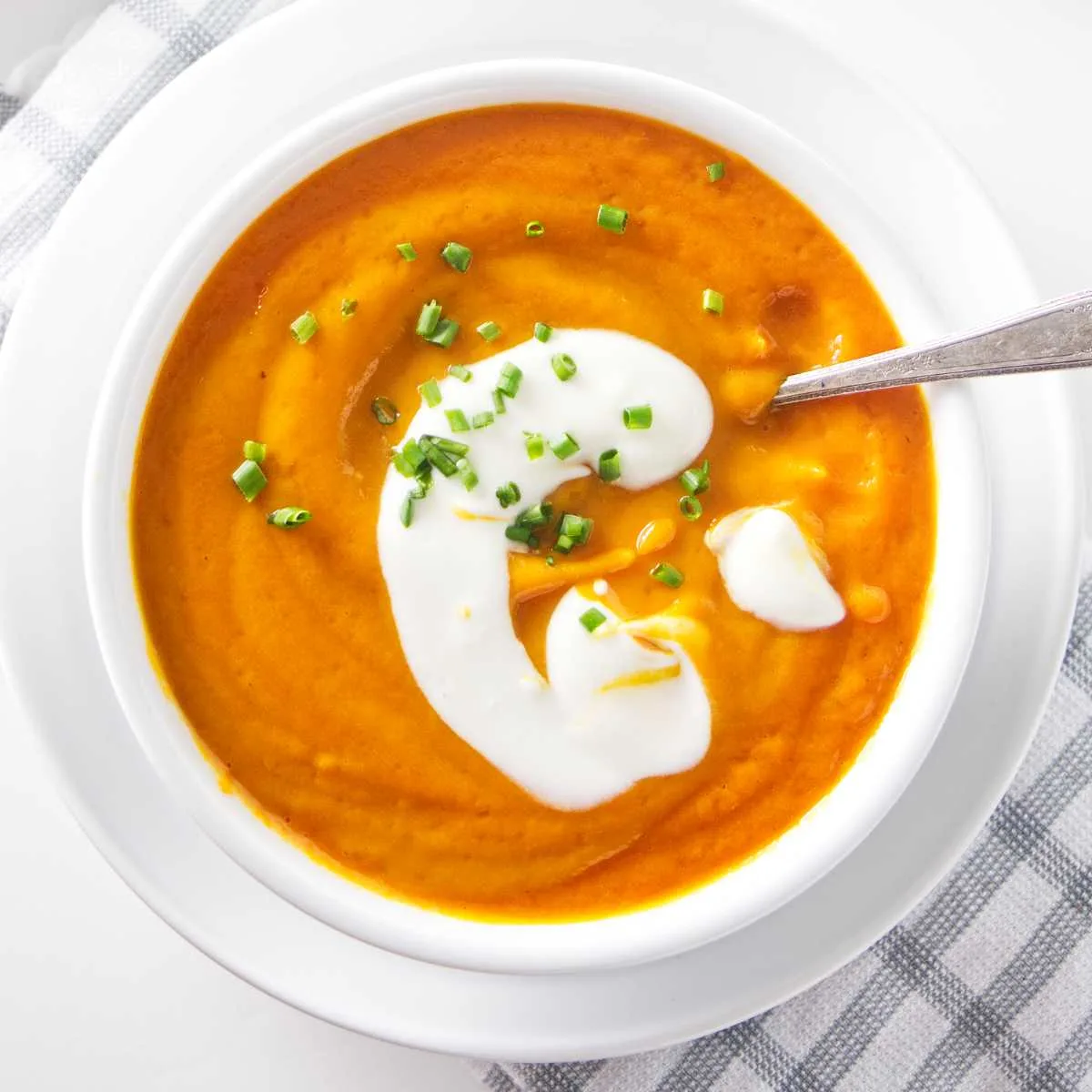 A bowl of carrot soup with a dollop of yogurt on top.