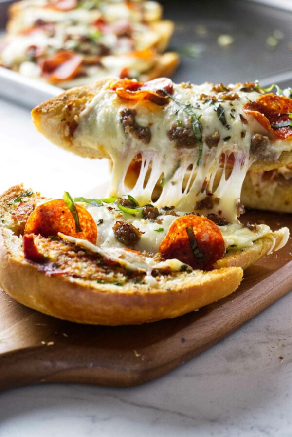 Several slices of garlic pizza bread on a cutting board.