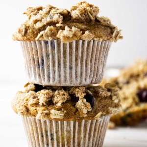 Two whole grain muffins stacked on top of each other.