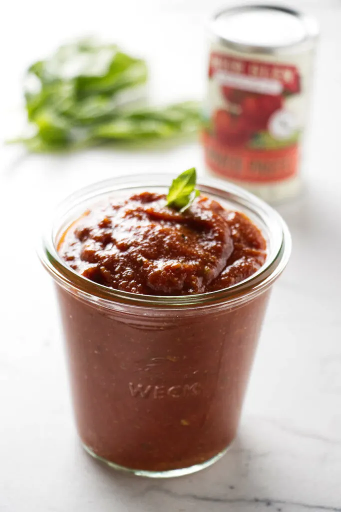 A jar filled with pizza sauce made with tomato paste.