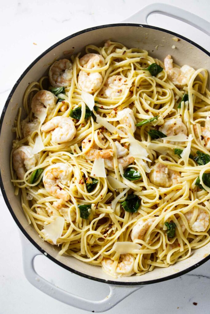 A large skillet filled with lemon garlic pasta and shrimp.