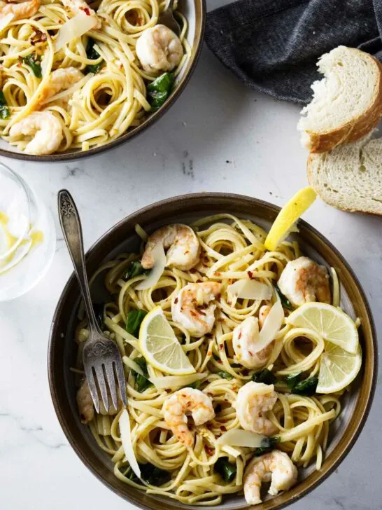 Two pasta bowls filled with garlic lemon shrimp pasta.