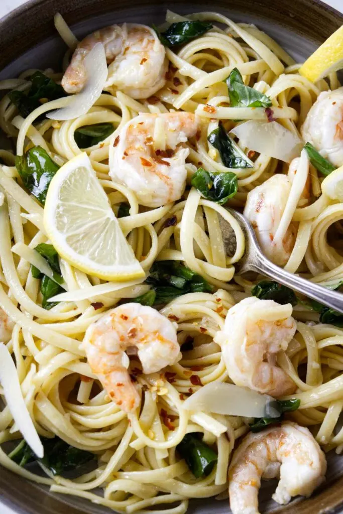 A fork in a bowl of lemon shrimp pasta.