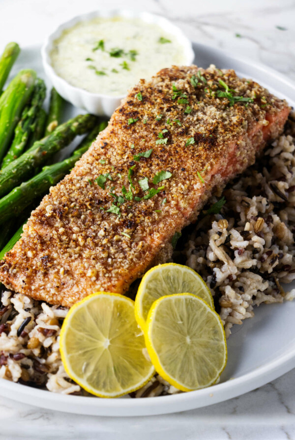 A pecan trout on a plate with wild rice.