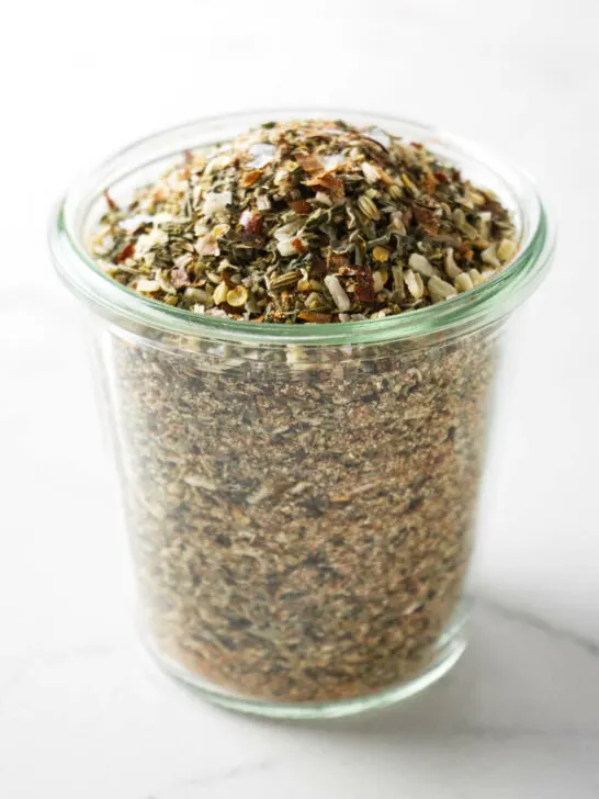 A jar filled with pizza seasoning.