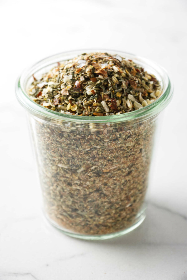 A jar filled with pizza seasoning.