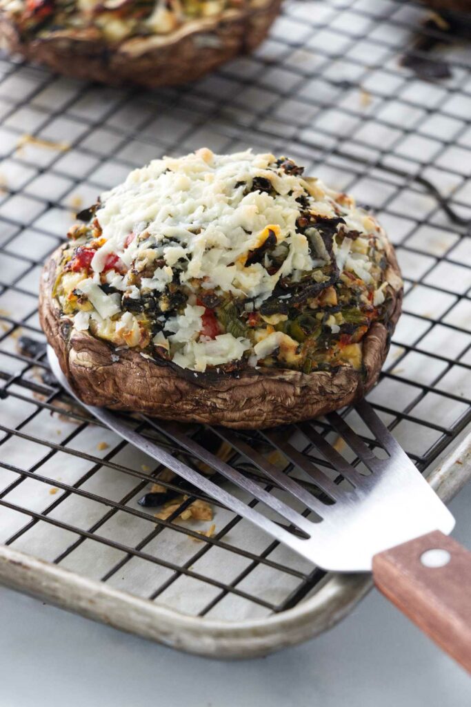 A freshly baked portobello mushroom stuffed with cheese and vegetables.