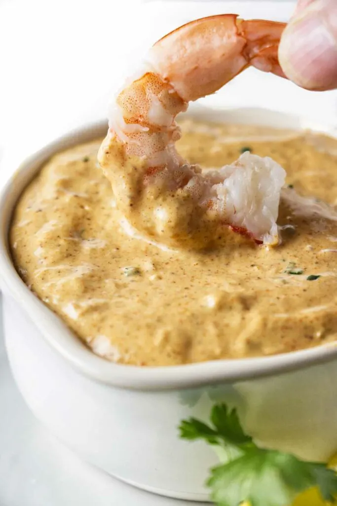 Dipping a shrimp in some spicy remoulade sauce.
