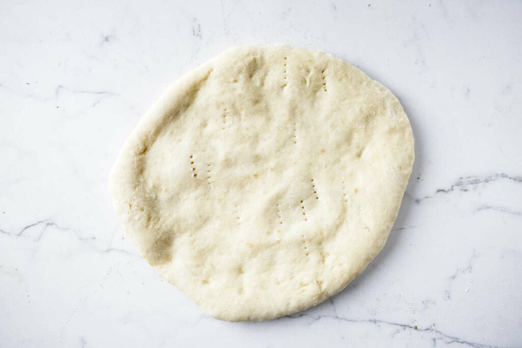 A partially cooked pizza crust.