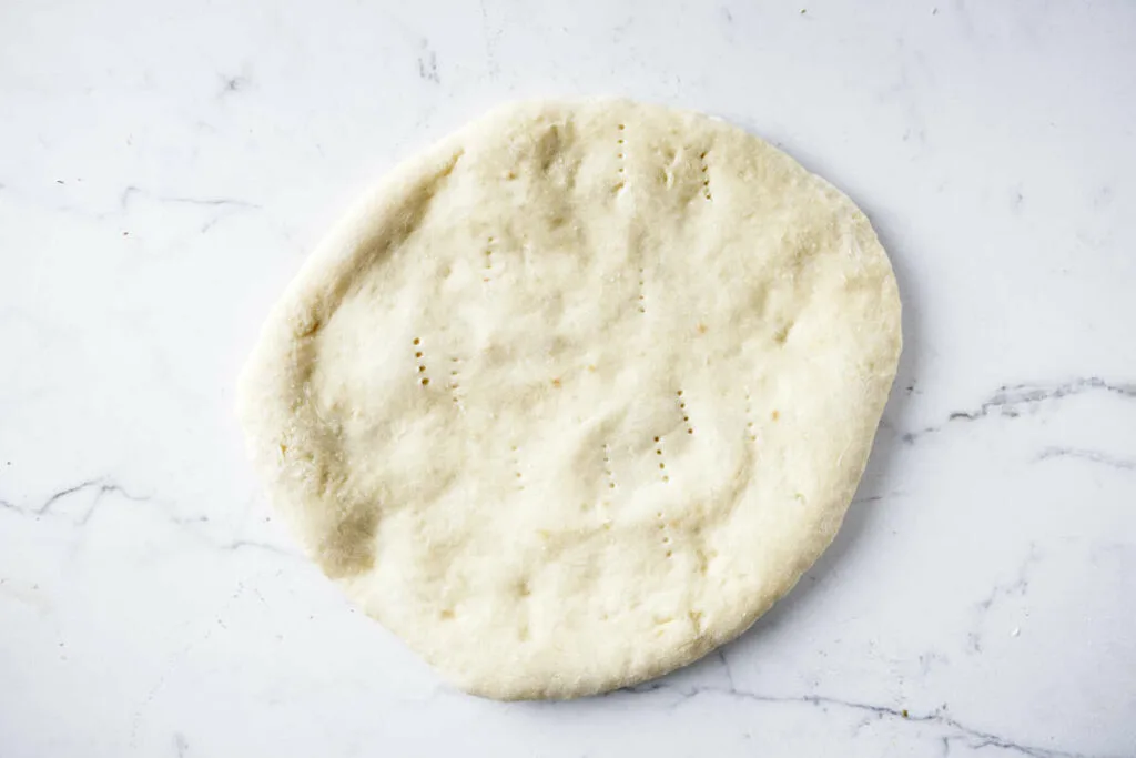 A partially cooked pizza crust.