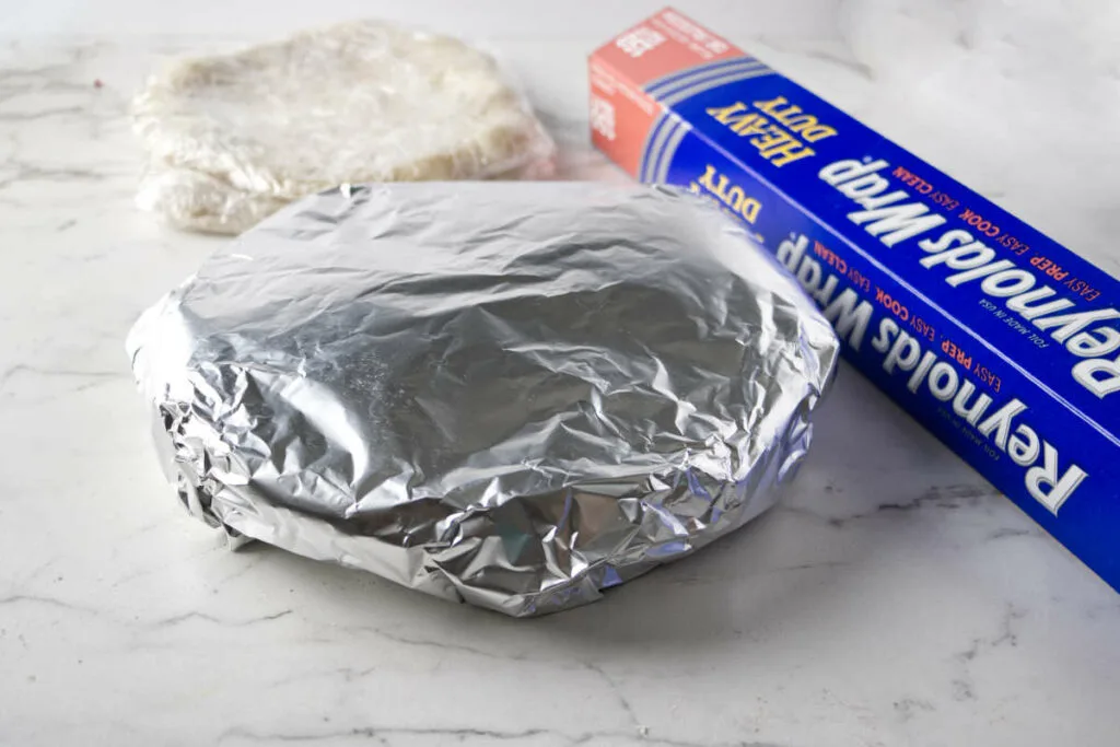 Wrapping pizzas in aluminum foil before freezing them.