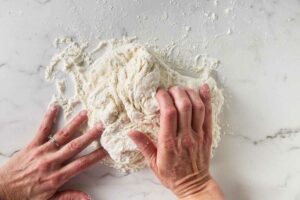 Kneading pizza dough.