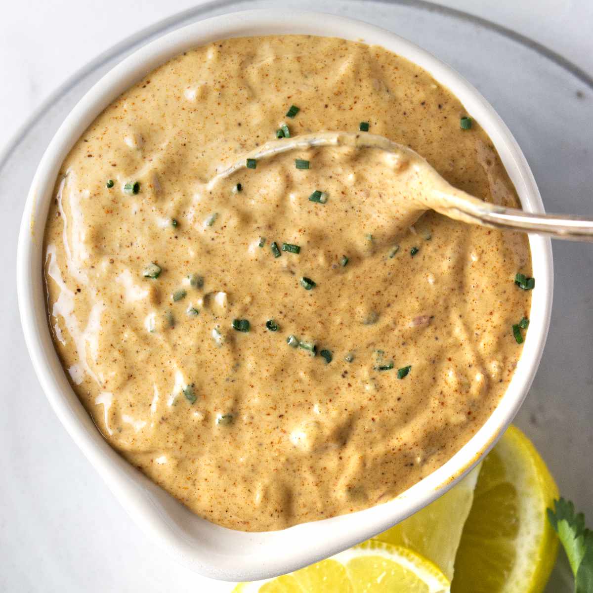Creamy remoulade sauce in a dish with a spoon.