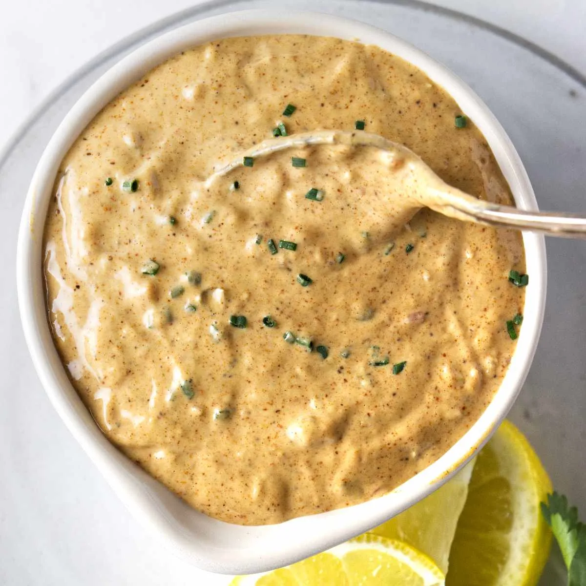 Creamy remoulade sauce in a dish with a spoon.