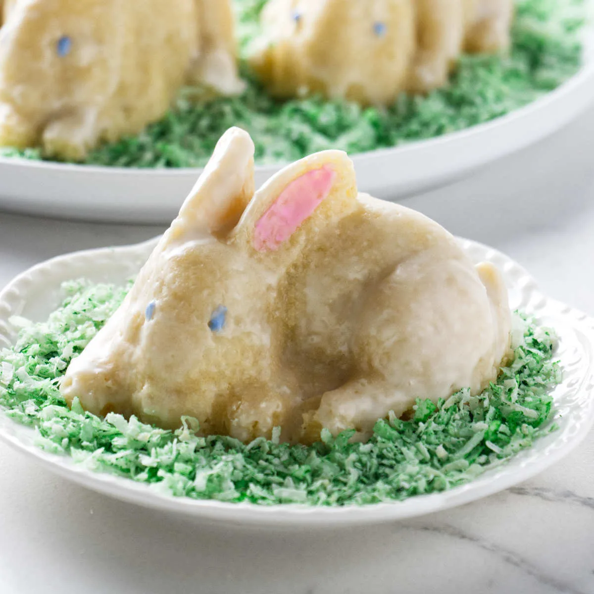 A small easter bunny cake on a plate.