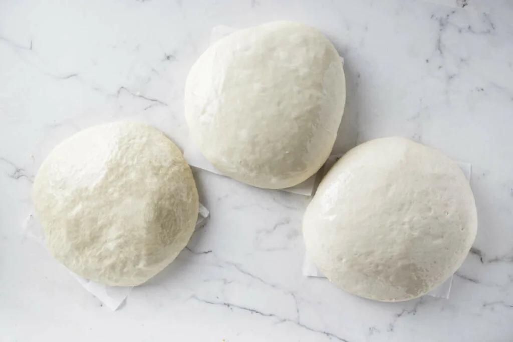 Prepping homemade pizza dough to store in the fridge.