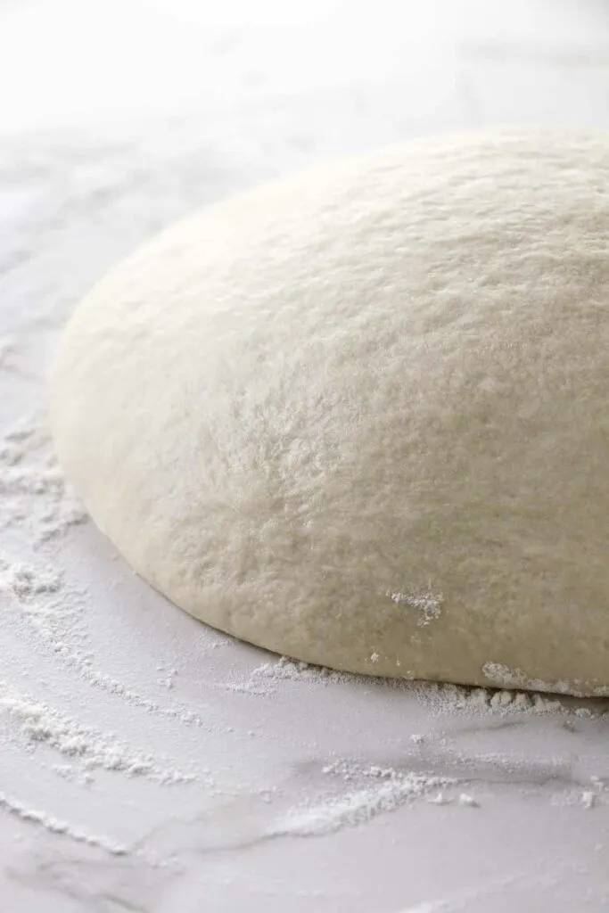 Letting pizza dough rise on a counter.