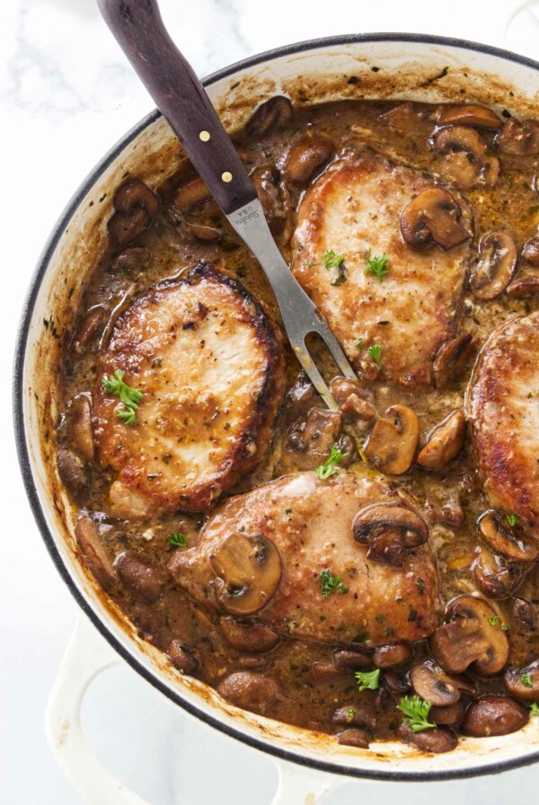 Pork marsala in a large skillet with a serving fork.