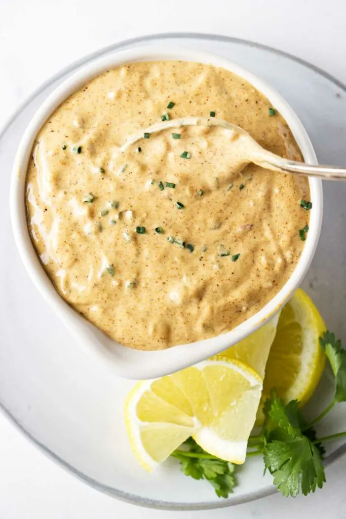 A spoon in a dish of creole remoulade sauce.