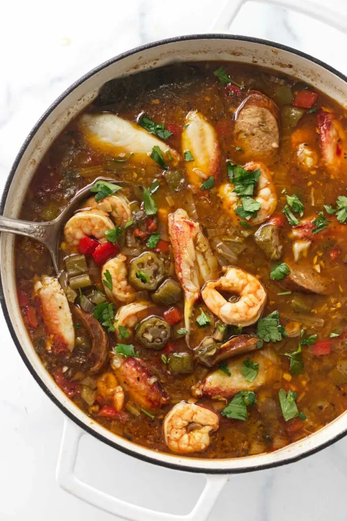 A large pot filled with crab, sausage and shrimp gumbo.