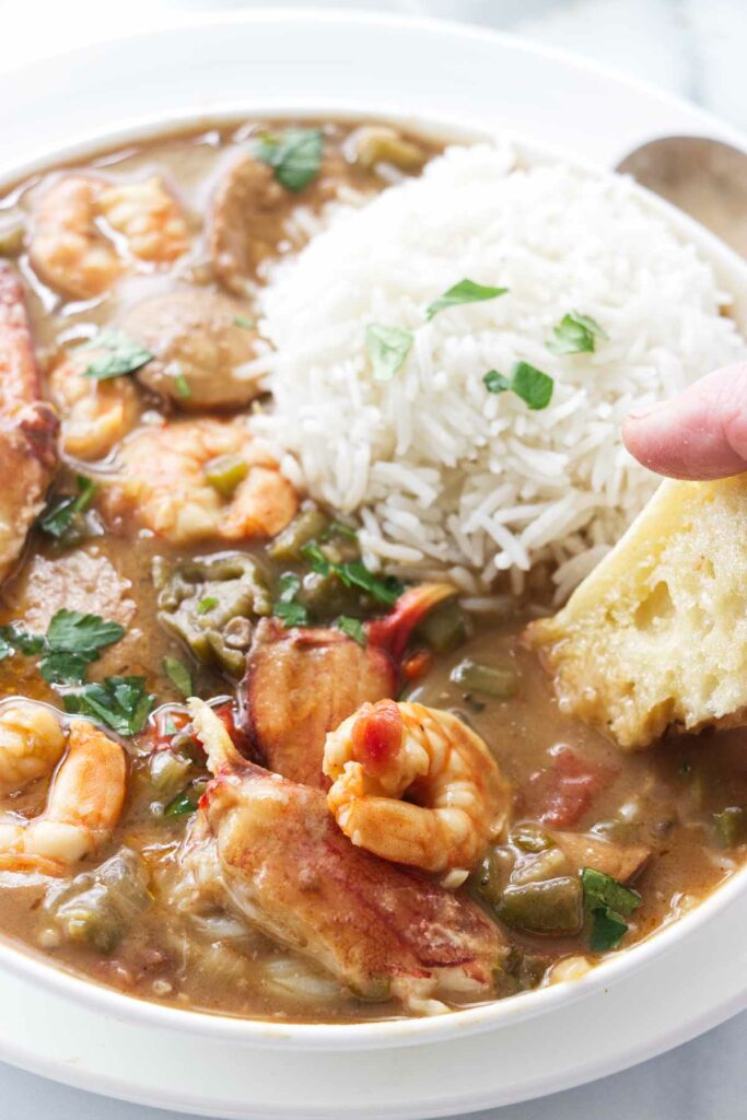 Dipping bread into a dish of crab and shrimp gumbo.