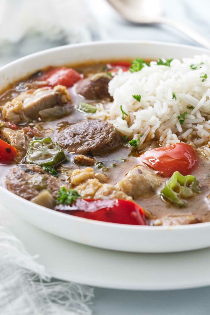 A bowl of Louisiana chicken and sausage gumbo with a scoop of rice.