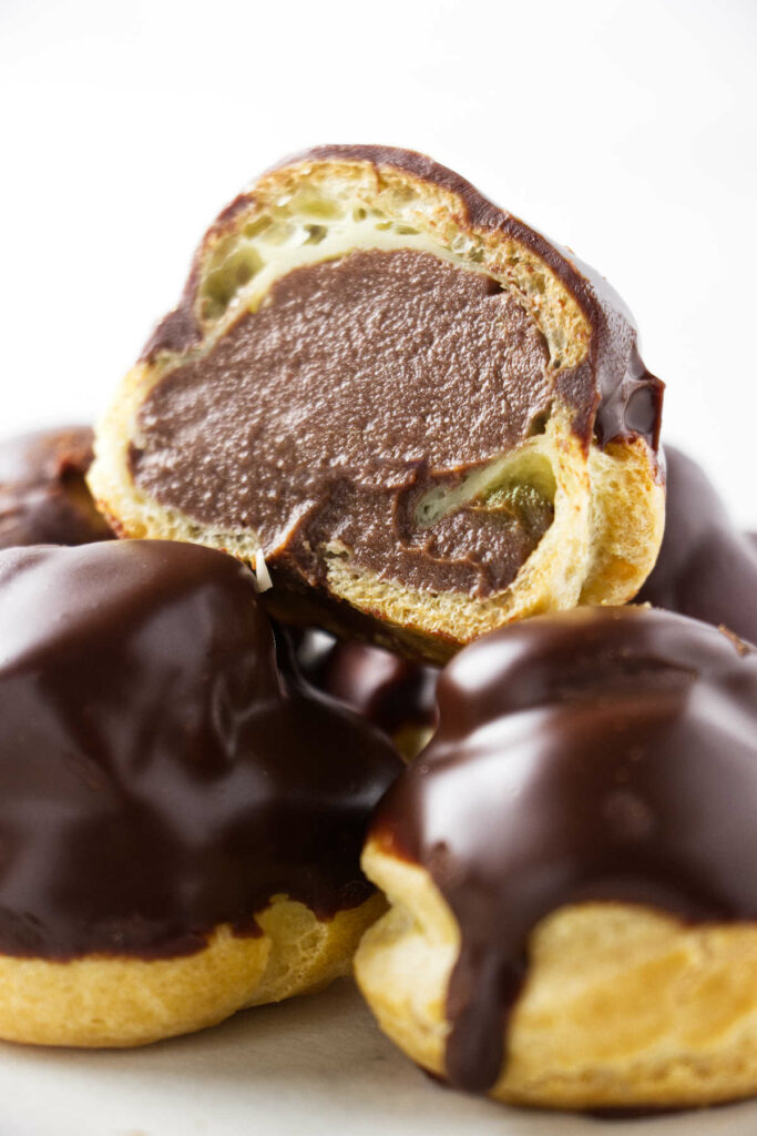 A chocolate filled profiterole sliced in half.