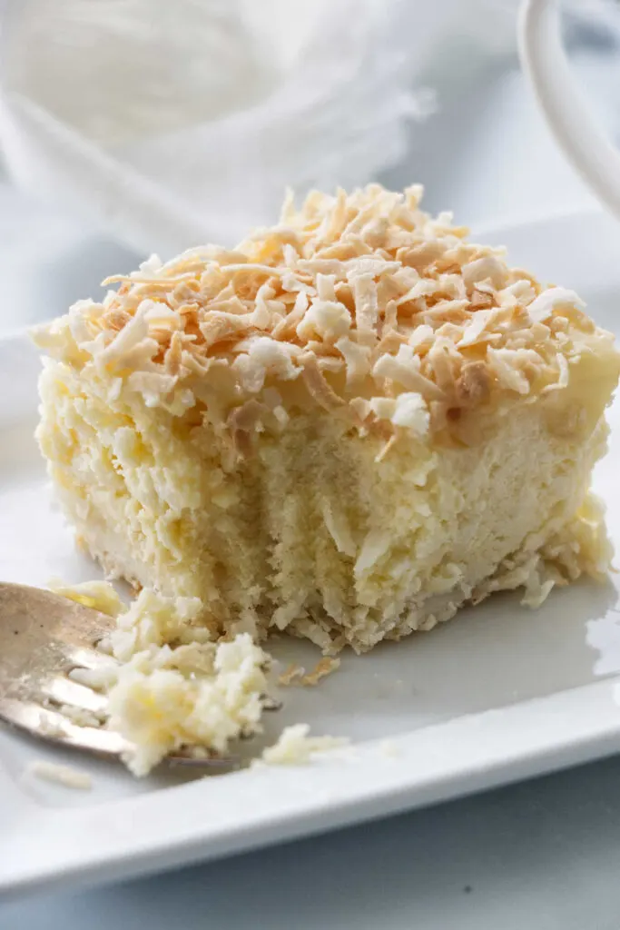 A fork cutting into coconut cheesecake bars.