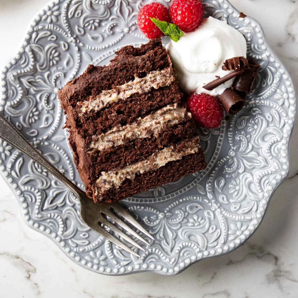 A slice of a chocolate cassata cake with four layers of ricotta filling.