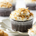 A chocolate coconut cupcake on a plate.