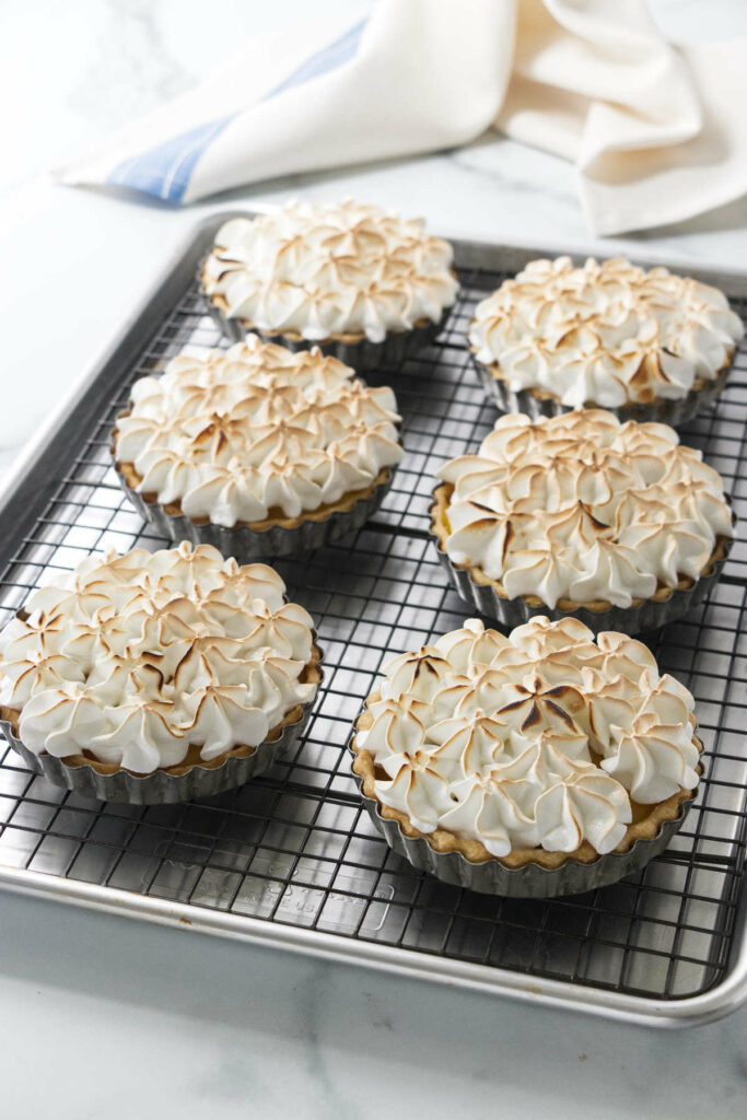 Several mini lemon tarts with meringue topping.