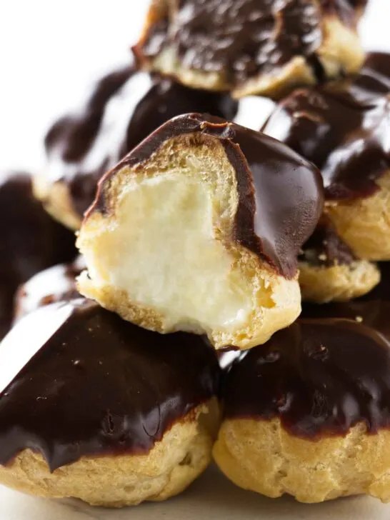 A stack of profiteroles filled with pastry cream.