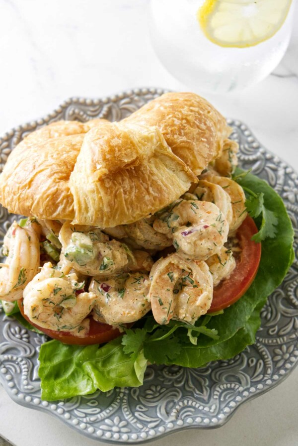 A prawn salad sandwich on a croissant.