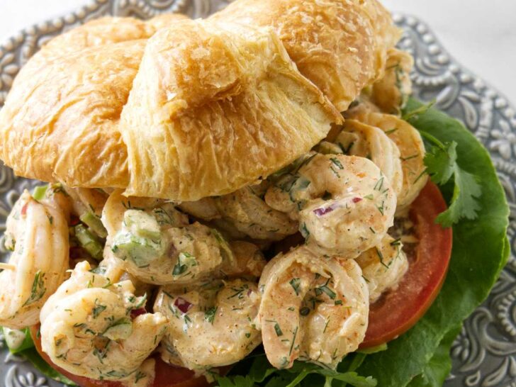 A prawn salad sandwich on a croissant.