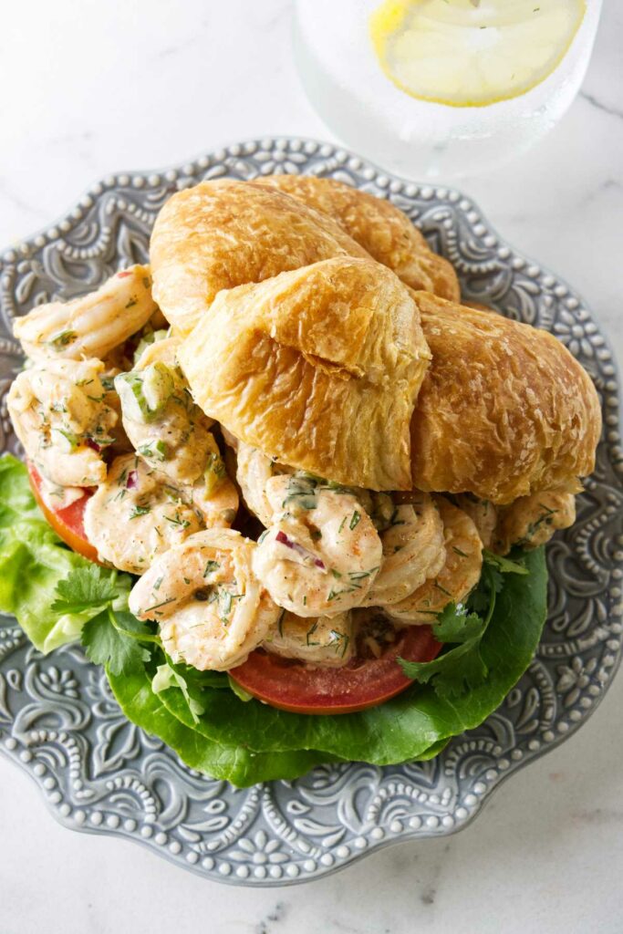 A shrimp sandwich on croissant bread. 