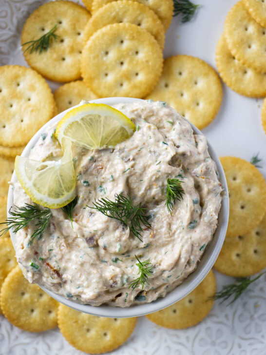 A bowl of smoked trout cream cheese dip next to several crackers.