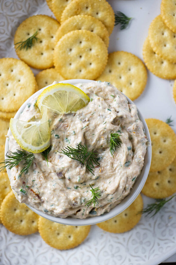 A bowl of smoked trout cream cheese dip next to several crackers.
