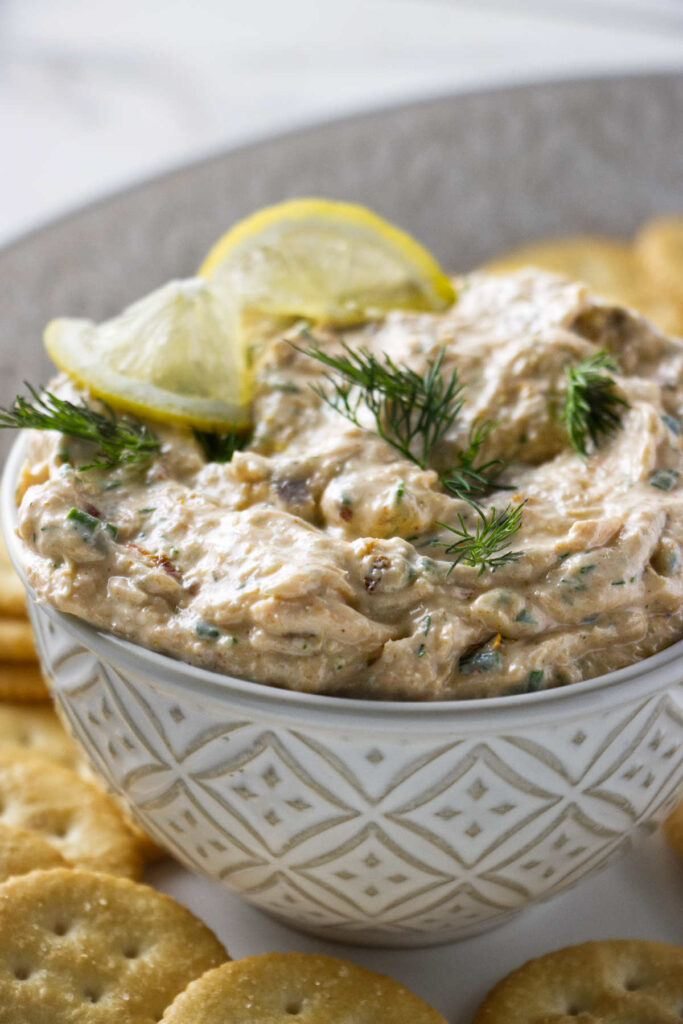 Smoked trout dip in a dish with a lemon slice.