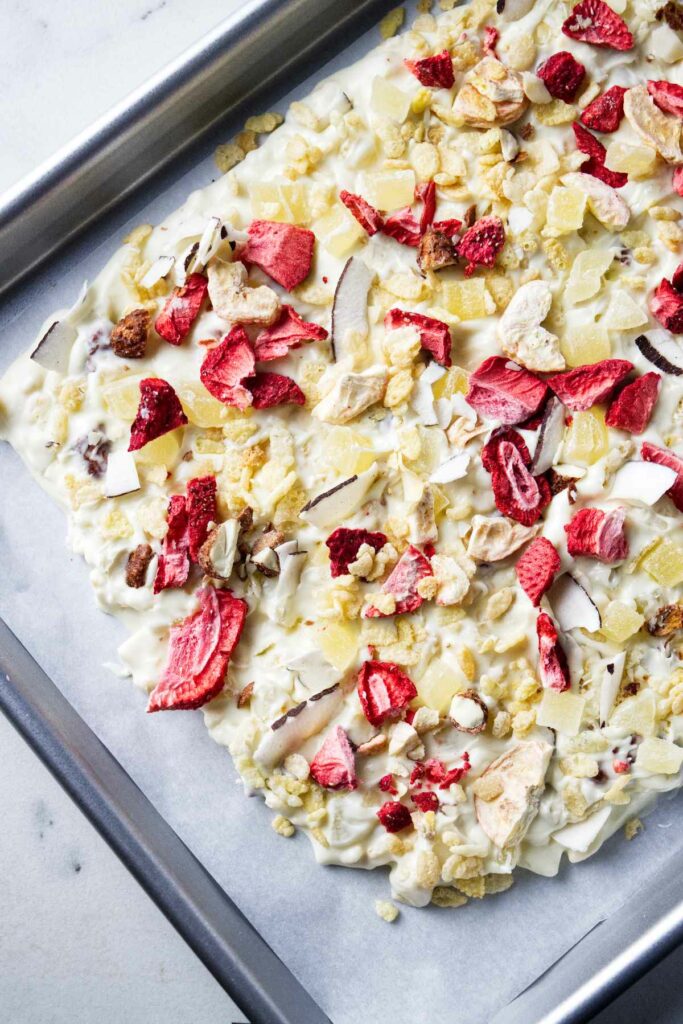 Letting white chocolate candy bark set up on a sheet pan.