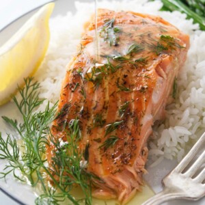 Drizzling butter over a cedar plank baked trout.