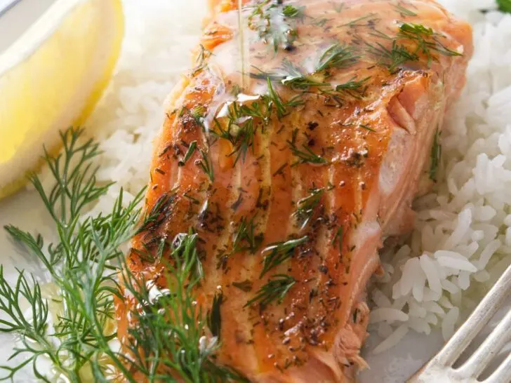 Drizzling butter over a cedar plank baked trout.