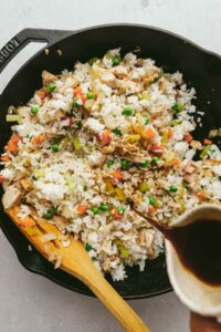 Pouring in the sauce for fried rice.