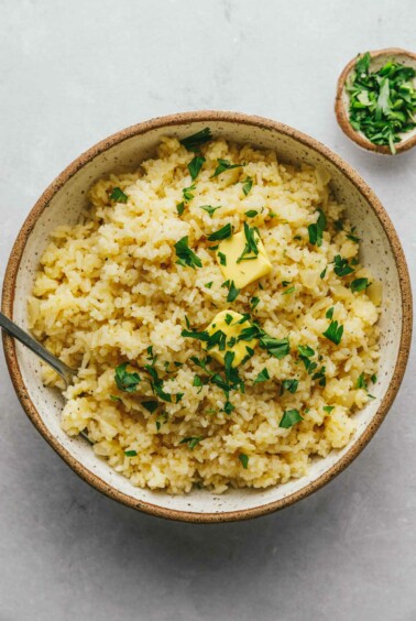 Sprinkling herbs on the garlic butter rice.