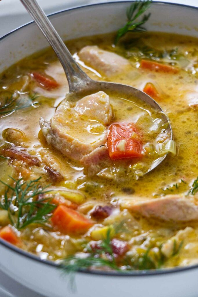 A spoon in a bowl of trout chowder.