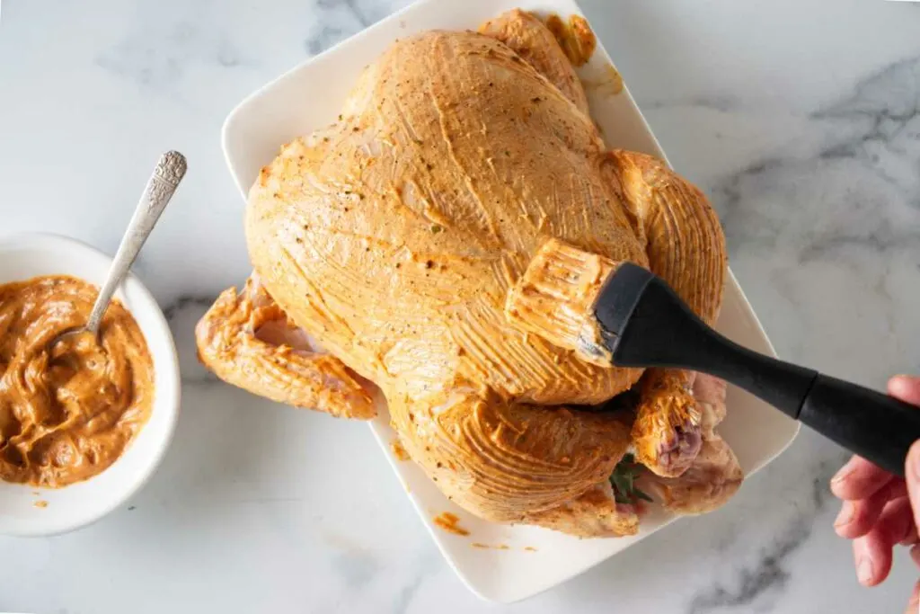 Brushing the seasoning sauce on the chicken.