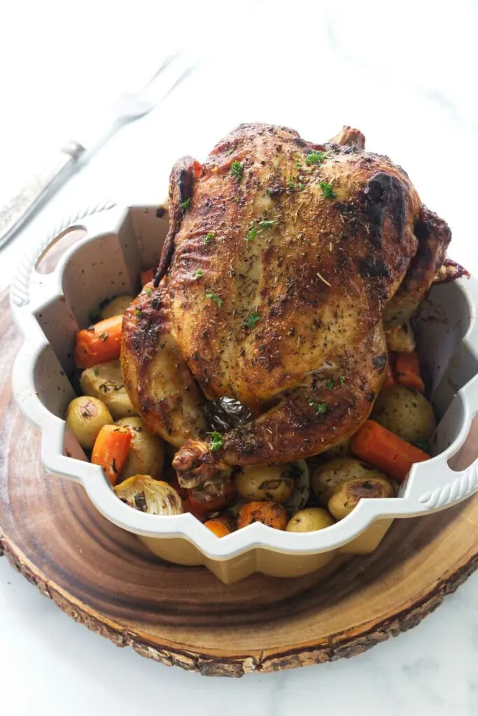 Bundt pan with a roasted whole chicken and vegetables.