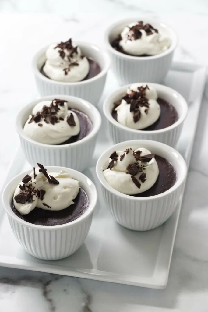 six servings of chocolate pots de creme on a tray.