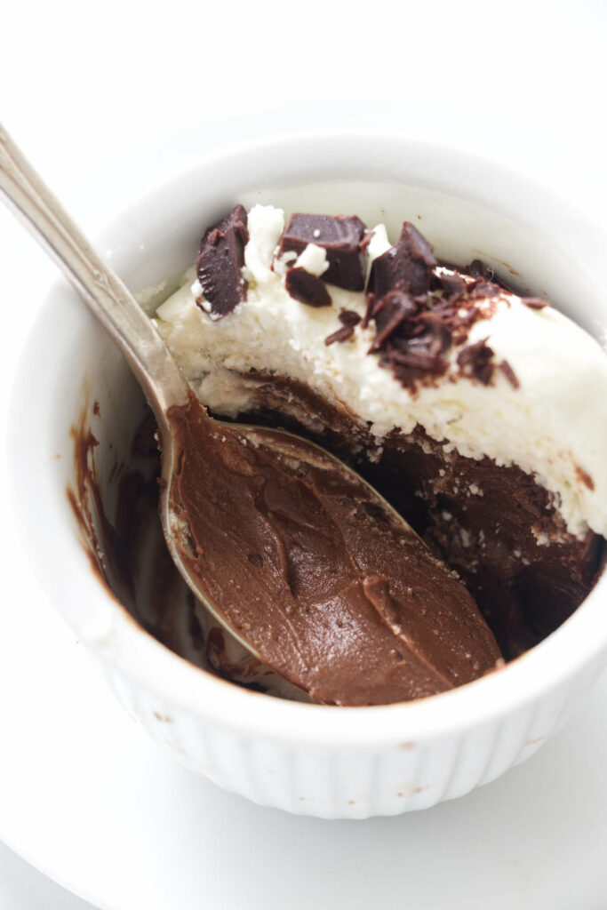 a spoon in a serving of chocolate pudding.