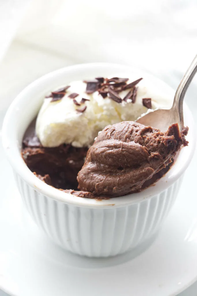 A serving of pots de creme with a spoonful being lifted from the dish.