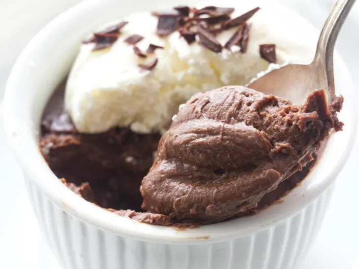 A serving of pots de creme with a spoonful being lifted from the dish.